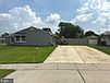 A driveway leading to a house

Description automatically generated